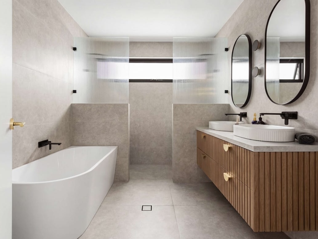 Fluted timber vanity with a freestanding bath and gold tapware