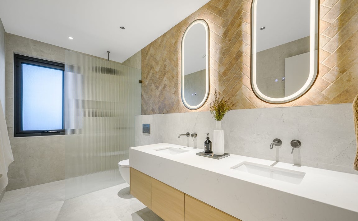 Brushed gold tiled feature wall with twin arched mirrors